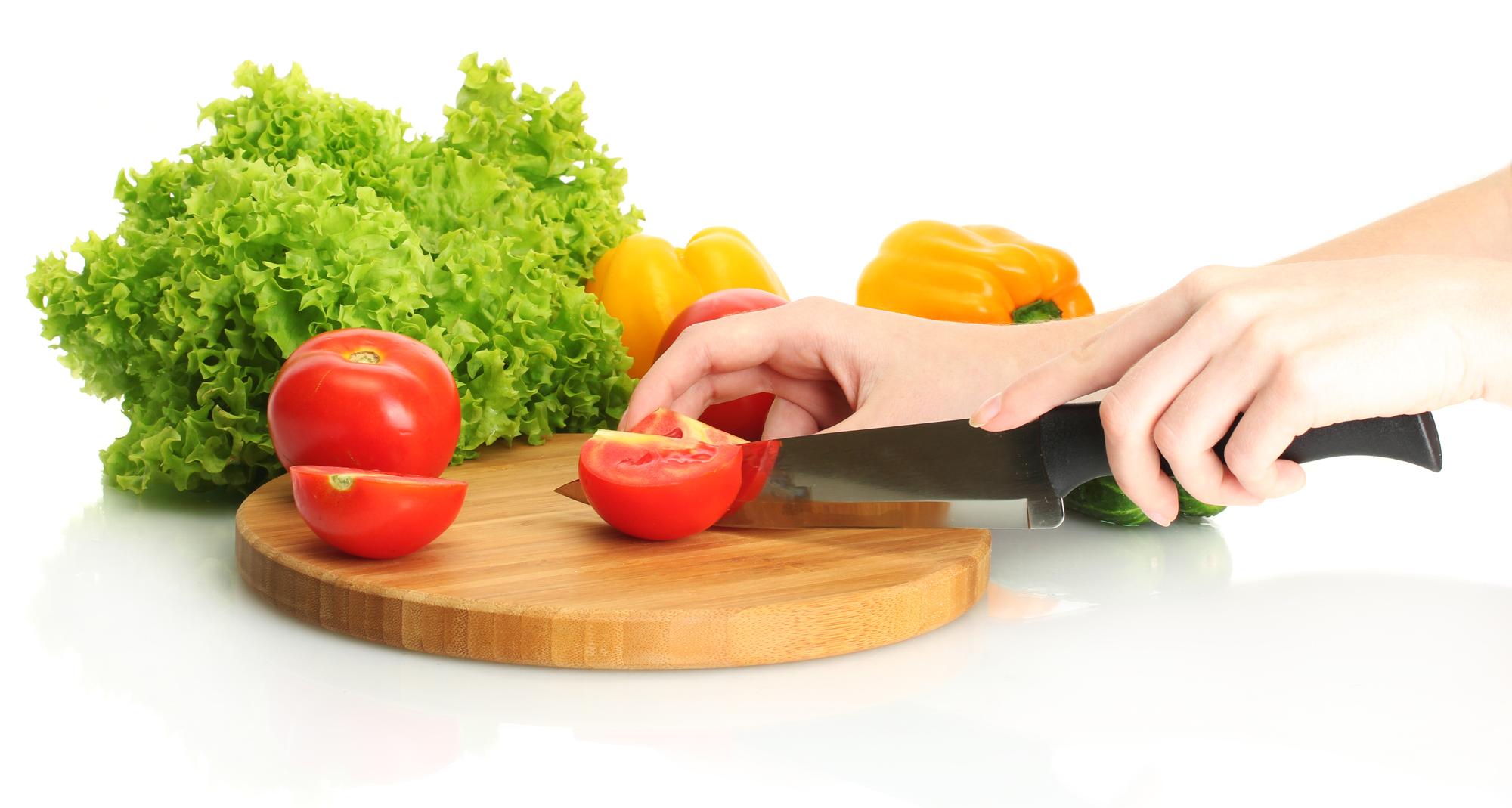 Hands slicing fresh produce